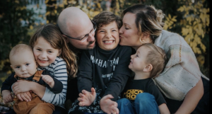 The smiling Moonen family, parents and children.